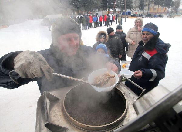 Мужчина накладывает еду в тарелки для посетителей седьмого всероссийского турнира Гусиные бои в посёлке Дубна Тульской области - Sputnik Молдова