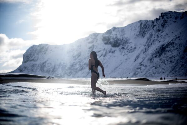 Молодая женщина ныряет в воду на Лофотенских островах в Новегии при температуре воздуха -5 и температуре воды +4 - Sputnik Молдова