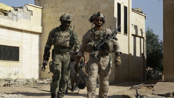 Armed men in uniform identified by Syrian Democratic forces as US special operations forces walk in the village of Fatisah in the northern Syrian province of Raqa on May 25, 2016 - Sputnik Moldova-România