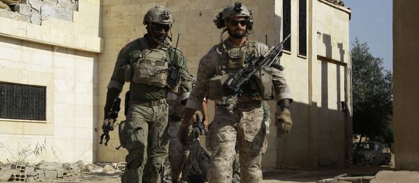Armed men in uniform identified by Syrian Democratic forces as US special operations forces walk in the village of Fatisah in the northern Syrian province of Raqa on May 25, 2016 - Sputnik Moldova