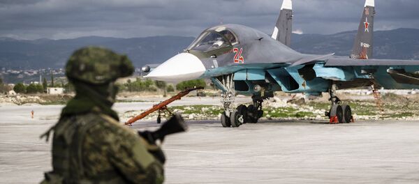 Un militaire russe devant un chasseur Soukhoï Su-34 sur la base aérienne de Hmeimim Un militaire russe devant un chasseur Soukhoï Su-34 sur la base aérienne de Hmeimim - Sputnik Moldova