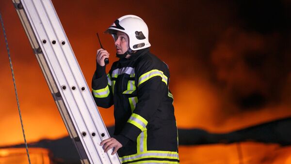 Сотрудник противопожарной службы во время тушения пожара - Sputnik Молдова