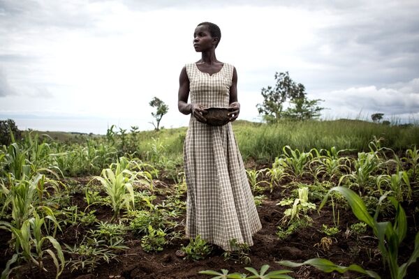 Женщина сеет семена в окрестностях временного лагеря для вынужденных переселенцев и репатриантов, Демократическая Республика Конго - Sputnik Молдова