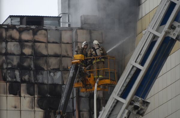 Сотрудники пожарной охраны МЧС во время тушения пожара в торговом центре «Зимняя вишня» в Кемерово - Sputnik Молдова