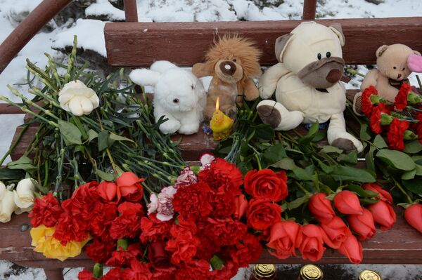 Цветы, свечи и мягкие игрушки возле здания торгового центра Зимняя вишня в Кемерово, где произошел пожар. - Sputnik Молдова