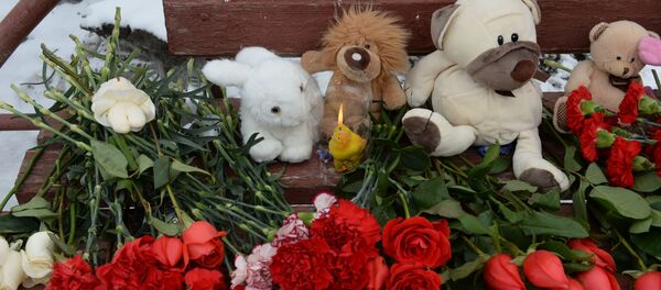 Цветы, свечи и мягкие игрушки возле здания торгового центра «Зимняя вишня» в Кемерово, где произошел пожар - Sputnik Молдова