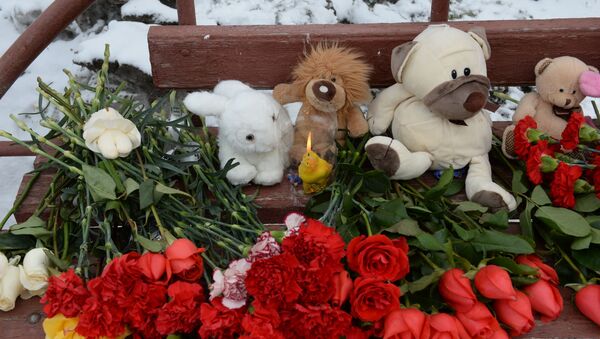 Цветы, свечи и мягкие игрушки возле здания торгового центра «Зимняя вишня» в Кемерово, где произошел пожар - Sputnik Молдова