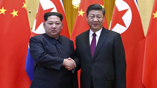 In this photo provided Wednesday, March 28, 2018, by China's Xinhua News Agency, North Korean leader Kim Jong Un, left, and Chinese President Xi Jinping shake hands in Beijing, China. - Sputnik Moldova-România