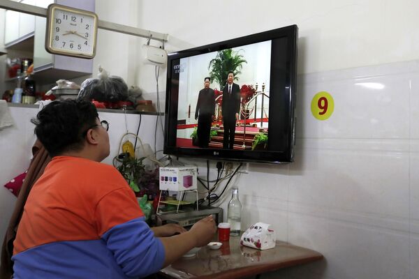 Мужчина смотрит телевизионный новости об официальном визите Ким Чены Ына в Китай - Sputnik Молдова