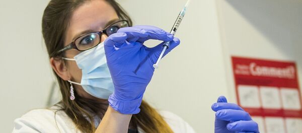 A nurse holds a dose of experimental vaccine cAd3-EBOZ Lau - Sputnik Moldova
