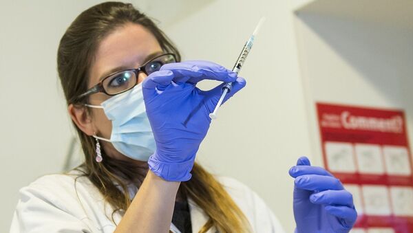 A nurse holds a dose of experimental vaccine cAd3-EBOZ Lau - Sputnik Moldova-România