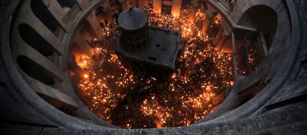 Христианские православные молящиеся зажигают свечи от Благодатного огня в церкви Гроба Господня в Старом городе Иерусалима - Sputnik Moldova