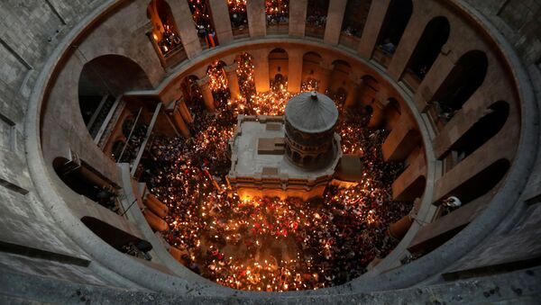 Верующие со свечами во время сошествия благодатного огня в Храм Гроба Господня в Иерусалиме - Sputnik Moldova