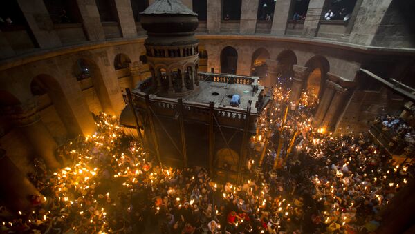 Christian Orthodox pilgrims hold candles during Holy Fire ceremony in the church of the Holy Sepulchre. (File) - Sputnik Moldova-România
