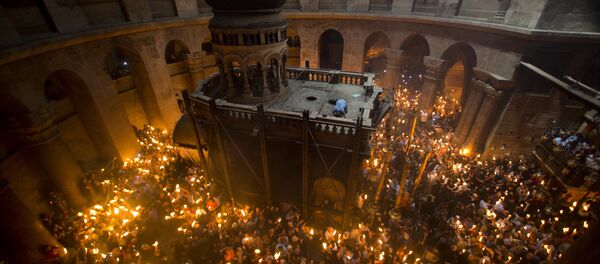 Christian Orthodox pilgrims hold candles during Holy Fire ceremony in the church of the Holy Sepulchre. (File) - Sputnik Moldova-România