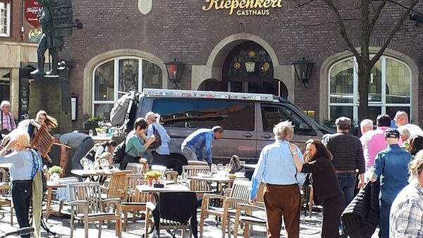 People stay in front of a restaurant in Muenster, Germany, Saturday, April 7, 2018 after a vehicle crashed into a crowd killing 2 people and injuring 20 others. - Sputnik Moldova-România