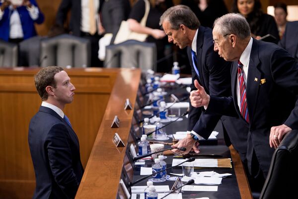 Генеральный директор Facebook Марк Цукерберг беседует с сенаторами Джоном Тьюном и Чаком Грассли в здании Капитолия в Вашингтоне - Sputnik Молдова