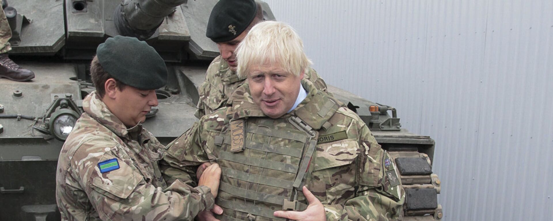 British Foreign Secretary Boris Johnson, right, has a flack jacket adjusted by an unidentified serviceman while visiting a NATO military unit outside Tallinn, Estoni - Sputnik Moldova-România, 1920, 12.11.2021