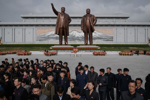 Жители после дани памяти у статуй лидеров КНДР Ким Ир Сена и Ким Чен Ира в Пхеньяне - Sputnik Молдова