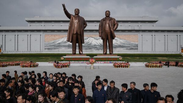 Жители после дани памяти у статуй лидеров КНДР Ким Ир Сена и Ким Чен Ира в Пхеньяне - Sputnik Молдова