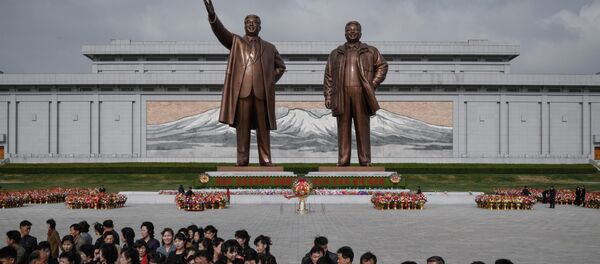 Жители после дани памяти у статуй лидеров КНДР Ким Ир Сена и Ким Чен Ира в Пхеньяне - Sputnik Молдова