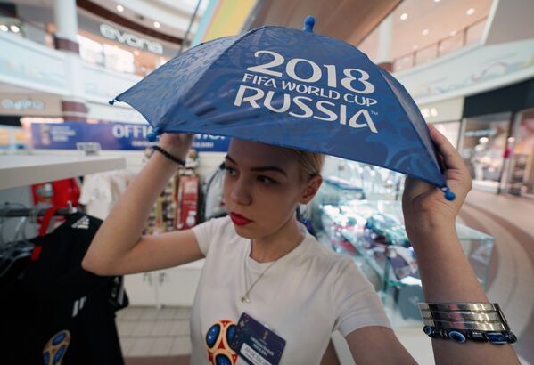 Девушка с зонтиком в официальном магазине в Калининграде по продаже сувениров и атрибутики к чемпионату мира по футболу 2018 в России - Sputnik Молдова