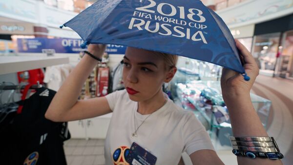 Девушка с зонтиком в официальном магазине в Калининграде по продаже сувениров и атрибутики к чемпионату мира по футболу 2018 в России - Sputnik Молдова