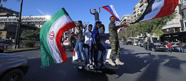 Syrian government supporters wave Syrian, Iranian and Russian flags as they chant slogans against U.S. President Trump during demonstrations following a wave of U.S., British and French military strikes to punish President Bashar Assad for suspected chemical attack against civilians, in Damascus, Syria, Saturday, April 14, 2018 - Sputnik Moldova
