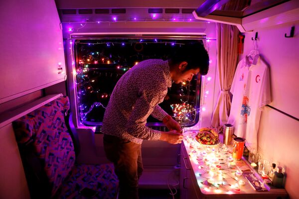 Молодой человек украшает свое купе Восточного экспресса свечами и гирляндами, Анкара - Карс, Турция - Sputnik Молдова