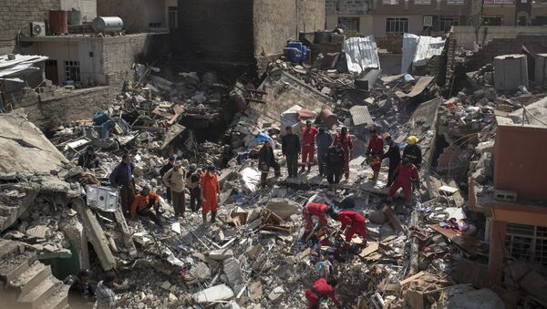In this Friday, March 24, 2017 photo, civil protection rescue teams work on the debris of a destroyed house to recover bodies of people killed during fighting between Iraqi security forces and Daesh militants on the western side of Mosul, Iraq - Sputnik Moldova-România