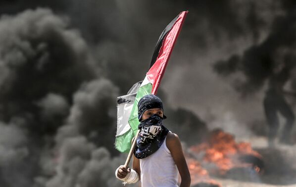 Палестинский демонстрант во время столкновений с израильскими силами у границы между сектором Газа и Израилем - Sputnik Moldova-România