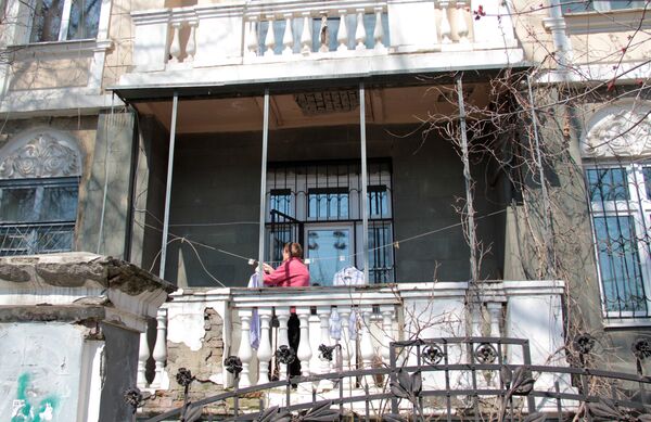 Центр города. Женщина развешивает белье на балконе старинной усадьбы. - Sputnik Молдова