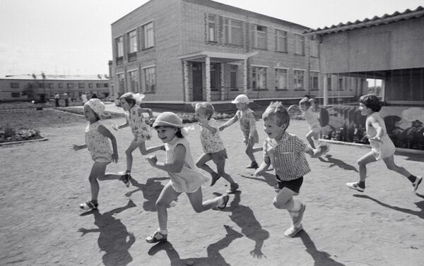 Дети весело играют на территории детского садика совхоза Большевик Уссурийского района - Sputnik Молдова