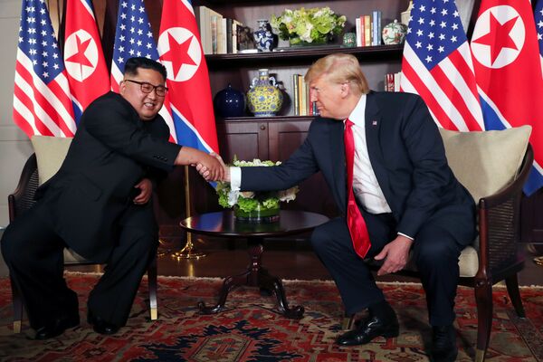 U.S. President Donald Trump shakes hands with North Korea's leader Kim Jong Un before their bilateral meeting at the Capella Hotel on Sentosa island in Singapore June 12, 2018. - Sputnik Молдова