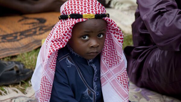 Кенийский ребенок слушает имама, когда он произносит проповедь во время праздника Ураза-байрам в Найроби, Кения - Sputnik Молдова