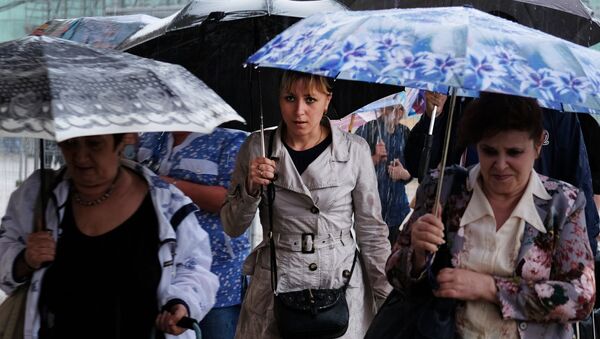 Прохожие на одной из улиц во время дождя. - Sputnik Moldova