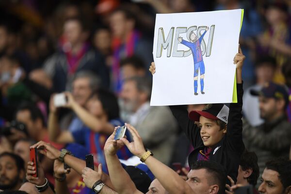 Юный болельщик с плакатом с изображением форварда Барселоны Лионеля Месси перед матчем между Барселоной и Реал Мадридом в Барселоне - Sputnik Молдова