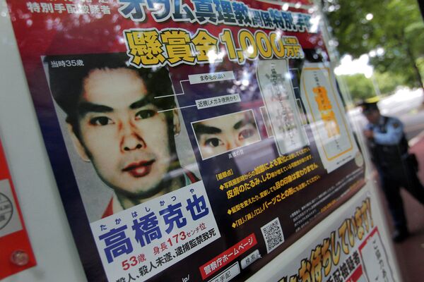 A police officer walks near a wanted poster of former Aum Shinrikyo cult member Katsuya Takahashi displayed at the metropolitan police department in Tokyo A police officer walks near a wanted poster of former Aum Shinrikyo cult member Katsuya Takahashi displayed at the metropolitan police department in Tokyo - Sputnik Moldova-România