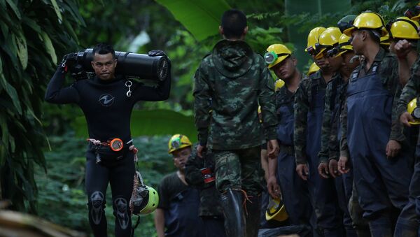A diver carries an oxygen tank as he leaves the Tham Luang cave complex, where 12 boys and their soccer coach are trapped, in the northern province of Chiang Rai, Thailand, July 6, 2018 - Sputnik Moldova-România