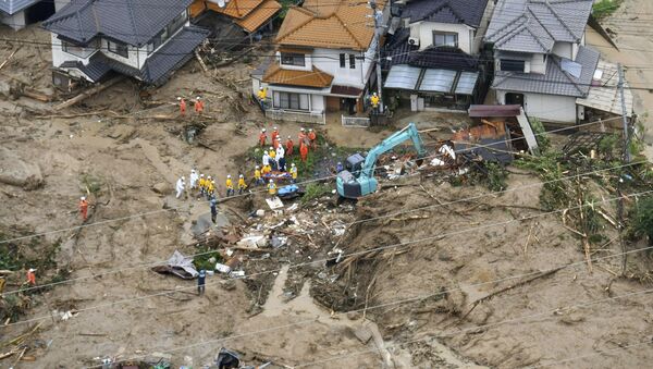 Rescue workers are seen next to houses damaged by a landslide following heavy rain in Hiroshima, western Japan, in this photo taken by Kyodo July 7, 2018 - Sputnik Moldova-România