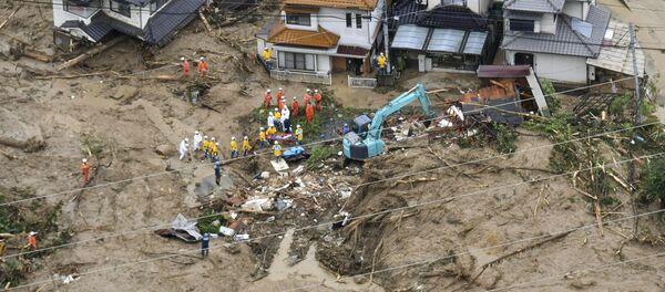Rescue workers are seen next to houses damaged by a landslide following heavy rain in Hiroshima, western Japan, in this photo taken by Kyodo July 7, 2018 - Sputnik Moldova-România