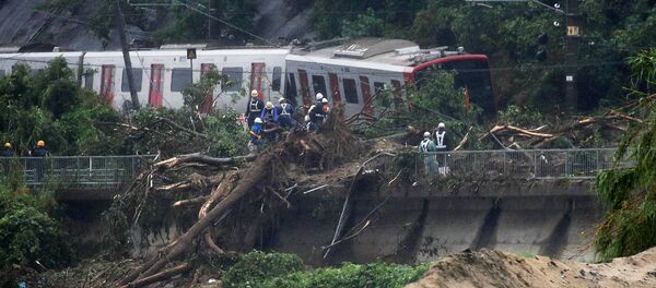 An emergency crew works at the site after a train derailed due to landslides caused by heavy rain in Karatsu city, Saga prefecture on July 7, 2018 - Sputnik Moldova-România