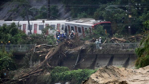 An emergency crew works at the site after a train derailed due to landslides caused by heavy rain in Karatsu city, Saga prefecture on July 7, 2018 - Sputnik Moldova-România