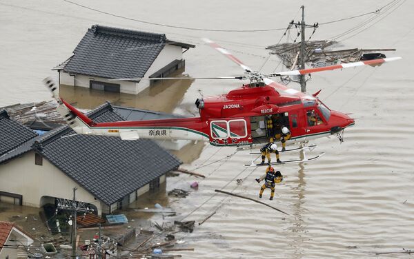 An aerial view shows a local resident being rescued from a submerged house by rescue workers using helicopter at a flooded area in Kurashiki, southern Japan, in this photo taken by Kyodo July 7, 2018 An aerial view shows a local resident being rescued from a submerged house by rescue workers using helicopter at a flooded area in Kurashiki, southern Japan, in this photo taken by Kyodo July 7, 2018 - Sputnik Moldova-România