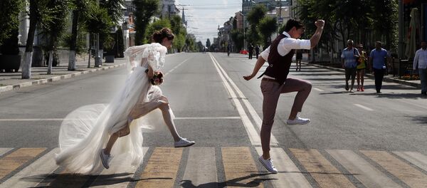 Молодожены позируют свадебному фотографу на дорожной зебре во время ЧМ-2018 в Самаре, Россия - Sputnik Молдова