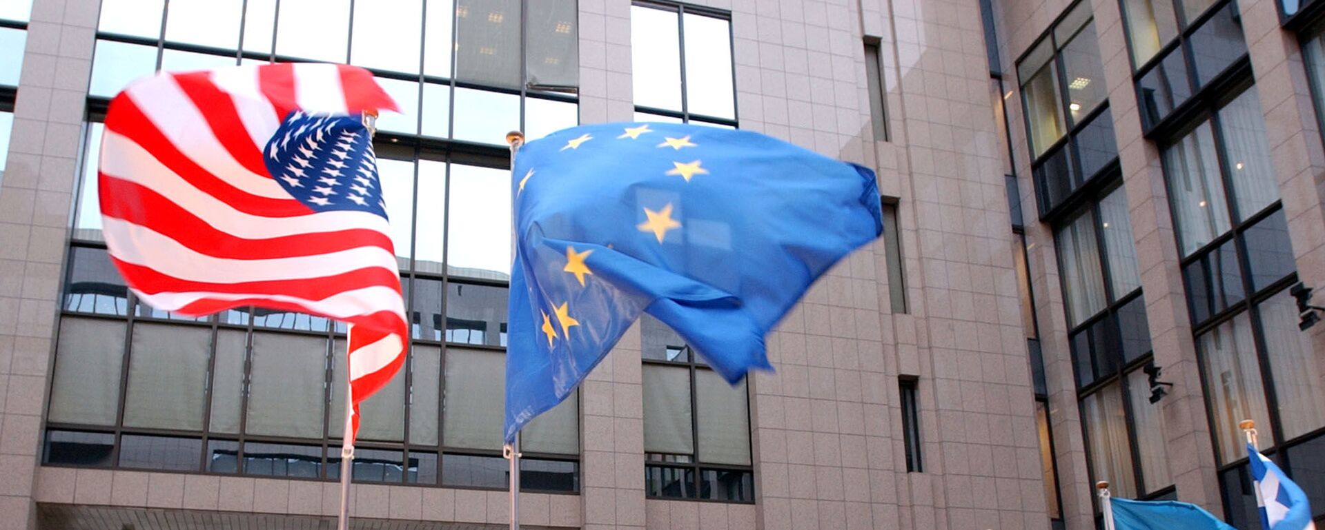 The US and EU flags, top left and right, fly in separate directions at the European Council building in Brussels - Sputnik Молдова, 1920, 01.02.2026