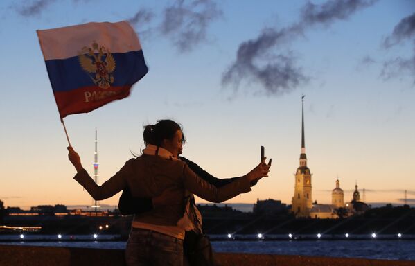 Российские болельщицы делают селфи с российским флагом в час ночи на набережной Невы в Санкт-Петербурге во время белых ночей - Sputnik Молдова