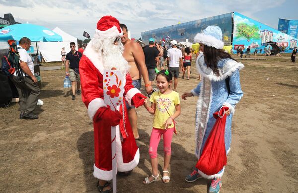 Гости фестиваля в костюмах Деда Мороза и Снегурочки на закрытии фестиваля Нашествие - Sputnik Молдова