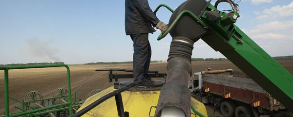 A worker loads fertilizers for treating fields of Irmen stud farm. A worker loads fertilizers for treating fields of Irmen stud farm. - Sputnik Moldova-România