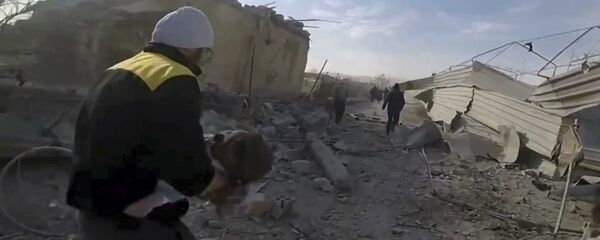 This frame grab from video released on Thursday, March. 1, 2018 by the Syrian Civil Defense White Helmets, which has been authenticated based on its contents and other AP reporting, shows a member of the Syrian Civil Defense group running as he holds a child who was wounded during airstrikes and shelling by Syrian government forces in the eastern Ghouta region near Damascus, Syria - Sputnik Moldova-România